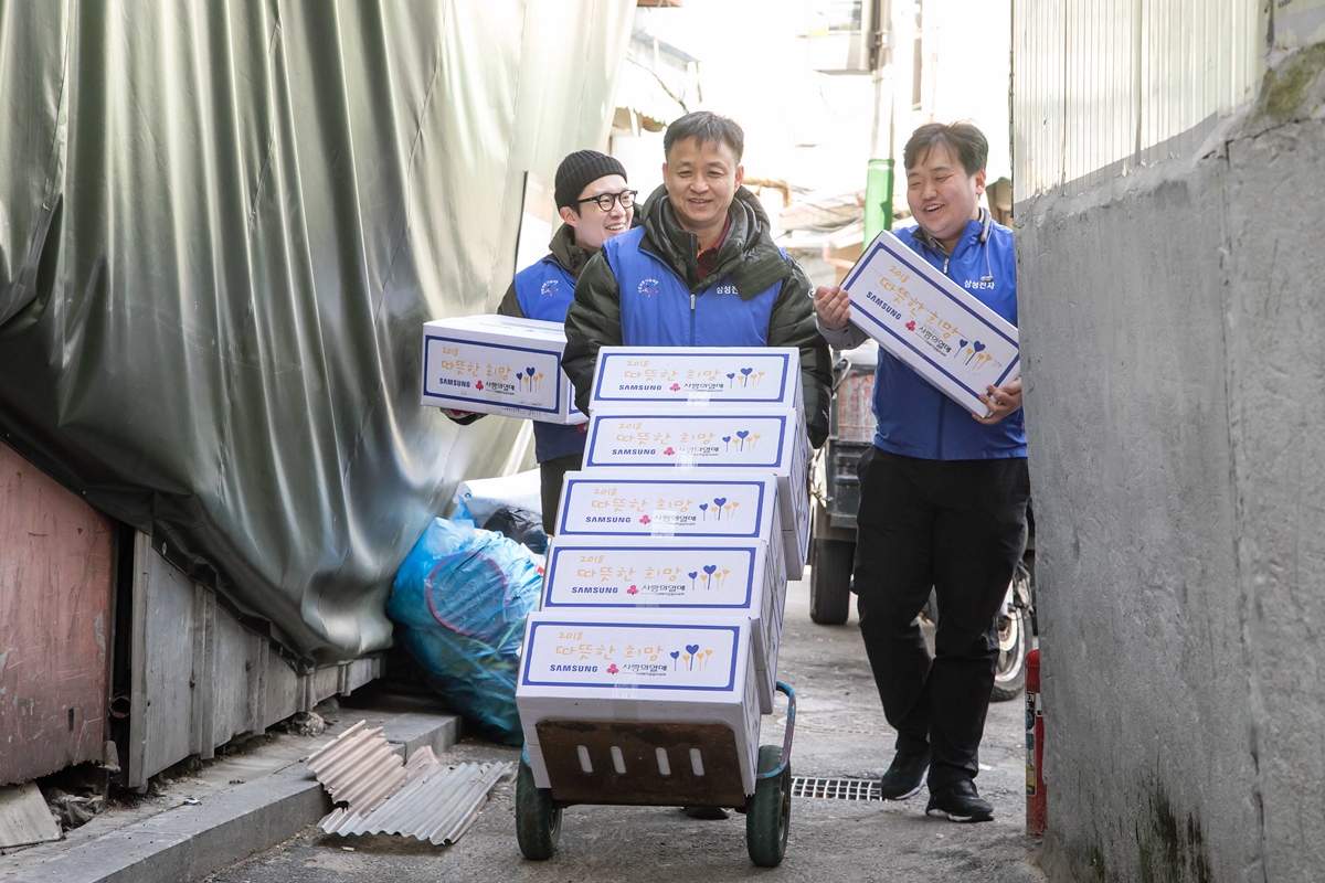10일 삼성전자 임직원들이 서울 동대문구에 위치한 쪽방을 찾아 거주하는 어르신들에게 전달할 생필품 세트를 나르고 있다.