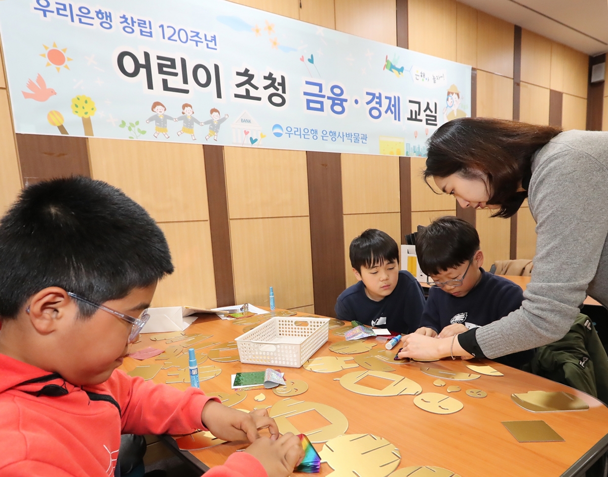 우리금융그룹은 지난달 30일 서울시 중구에 소재한 우리은행 박물관에서 유치원생, 초등학생들을 대상으로 ‘어린이 금융·경제교실’을 개최했다. 어린이들이 황금돼지 저금통을 직접 만들고 있다.