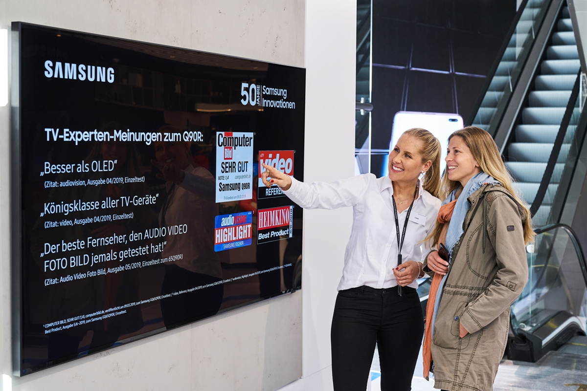 독일 프랑크푸르트 시내에 위치한 삼성 쇼케이스 매장에서 판매 직원이 고객에게 영상·음향기기 전문 매체들로부터 호평받은 QLED TV를 소개하고 있다.