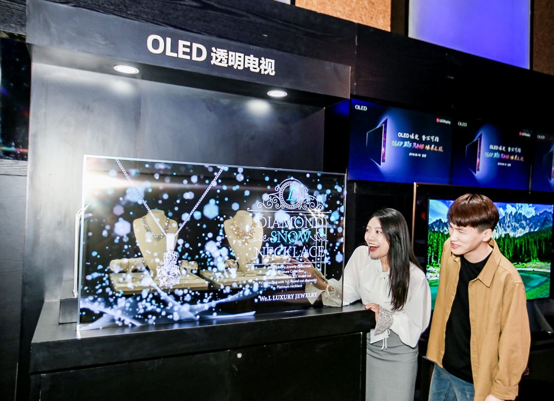 중국 베이징에서 열린 OLED 빅뱅 미디어 데이 행사에서 참석자들이 LG디스플레이의 55인치 투명 OLED 디스플레이를 관람하고 있다.