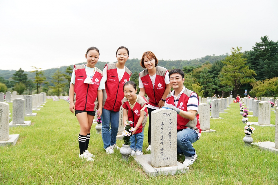 롯데건설 임직원과 가족들이 자매결연 묘역에서 봉사활동 후 기념 촬영을 하고 있다.